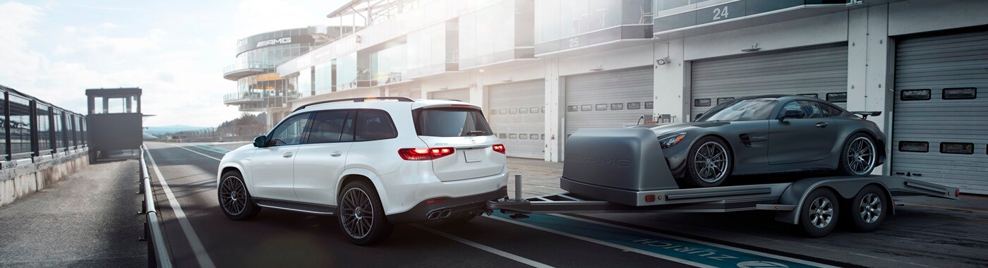 White Mercedes-Benz AMG GLS SUV towing an AMG model