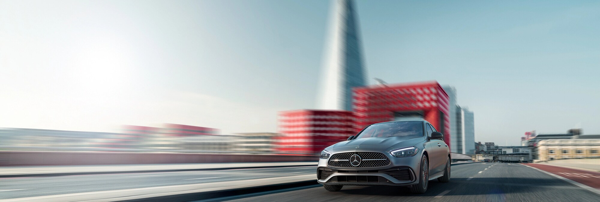 2023 Mercedes-Benz C-Class Sedan driving down a road.