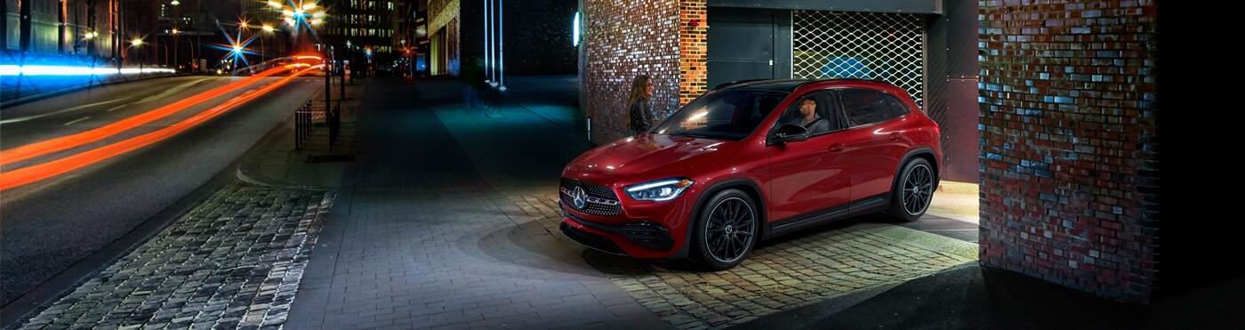 Red Mercedes-Benz GLA pulling onto a city street