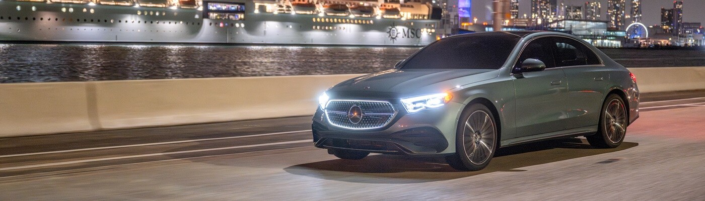 Mercedes-Benz E-Class driving on a city street at night